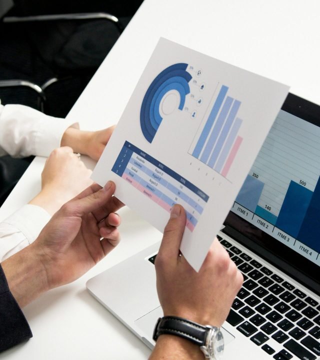 Business professionals discussing data charts and graphs in a modern office setting.